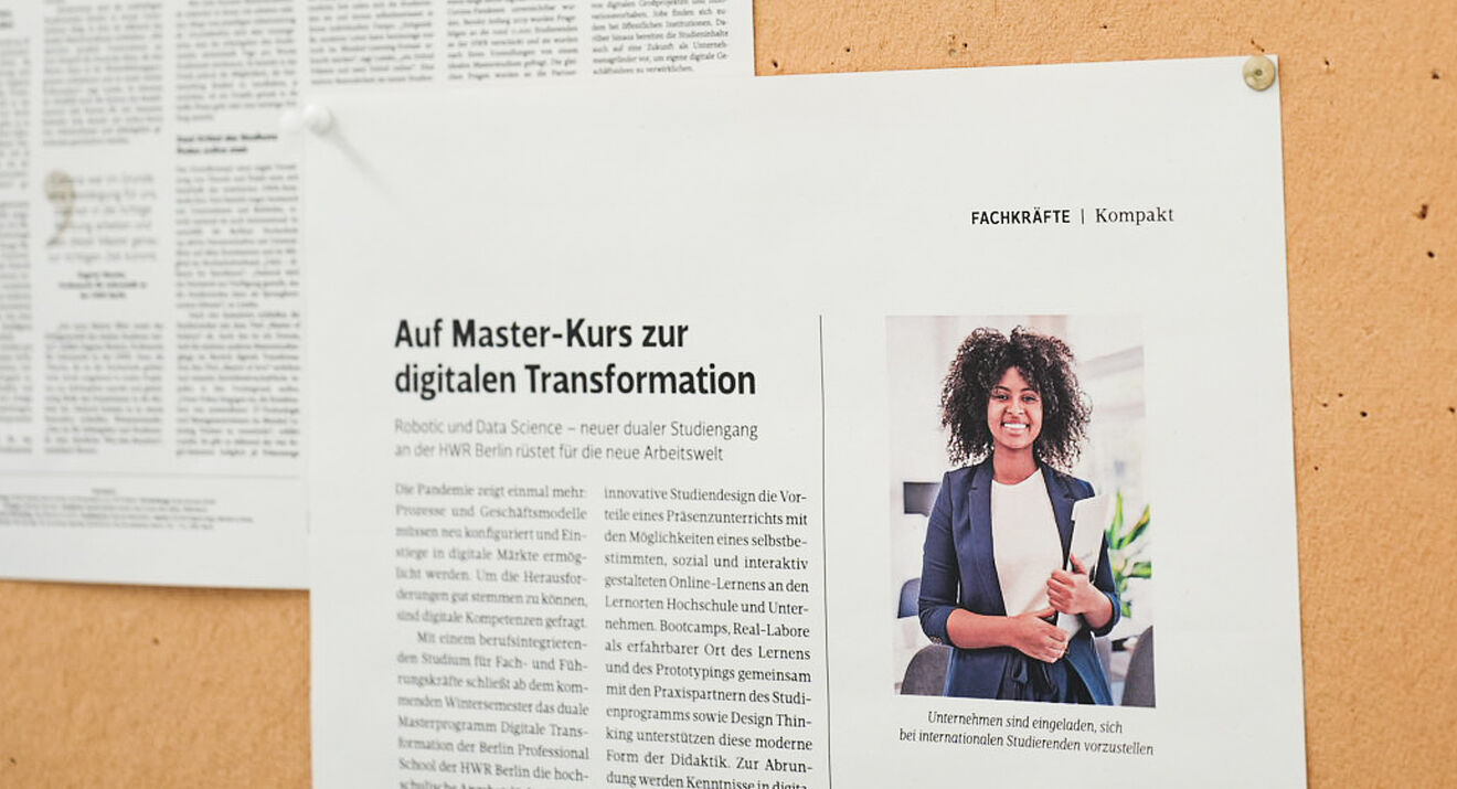 Zeitungsartikel zum Studiengang an einer Pinnwand 